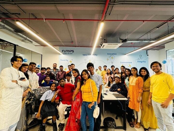 The Futops team in front of the company core-values wall